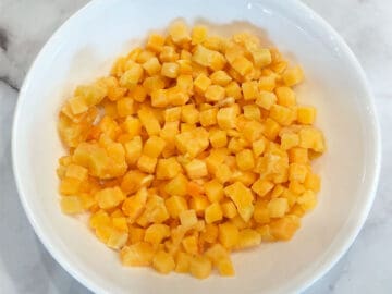 Frozen butternut squash cubes in a microwave-safe bowl.