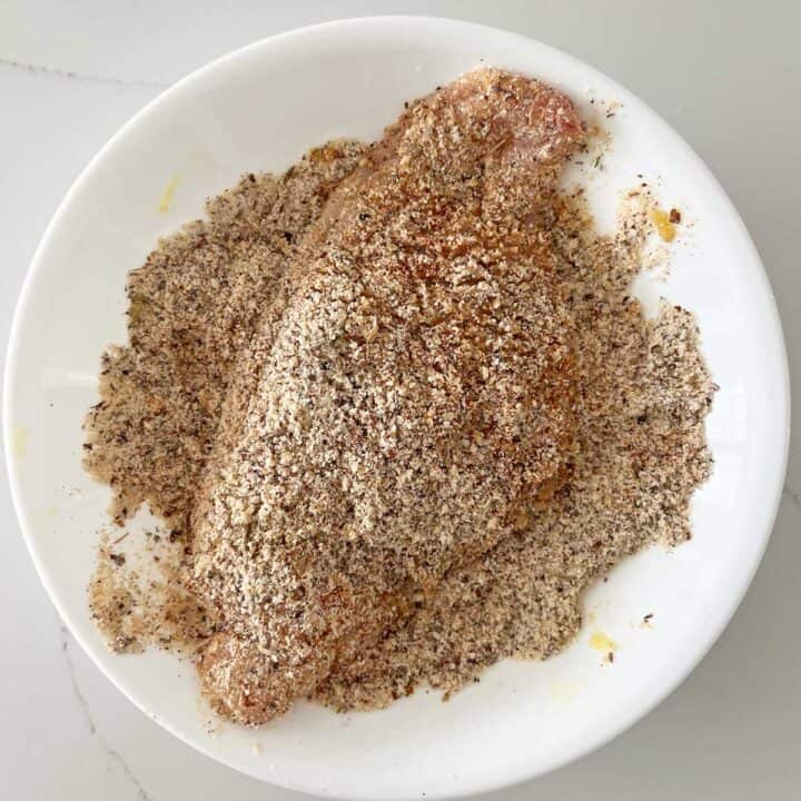 Dredging the fish in the almond meal coating.