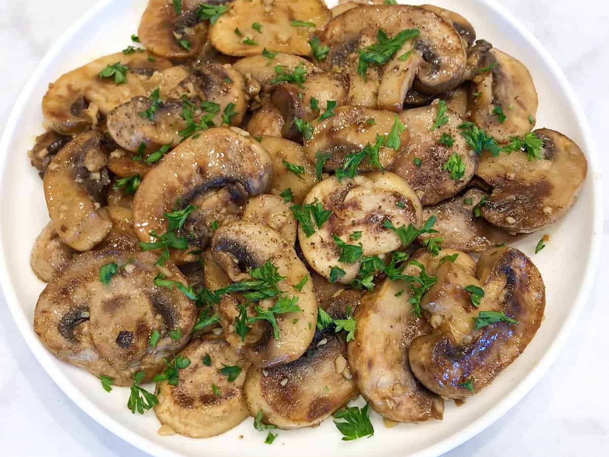 Garnishing the mushrooms with parsley.