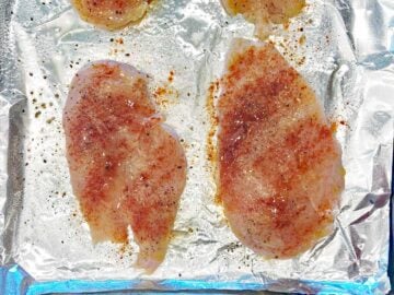 The chicken pieces are in the pan, oiled and seasoned.