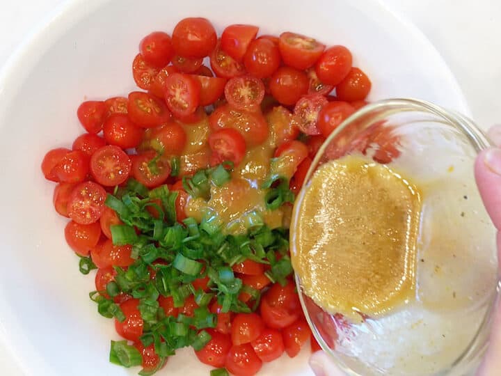 Pouring the dressing over the salad.