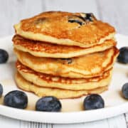 A stack of protein pancakes garnished with blueberries.