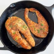 Salmon steak in a cast-iron skillet.
