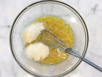 Whisking eggs, spices, and parmesan.