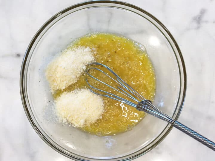 Whisking eggs, spices, and parmesan.