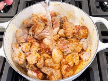 Adding water to the stew.