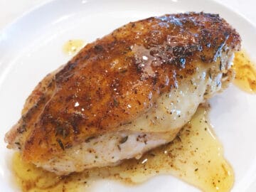 Pouring the pan juices over the chicken.