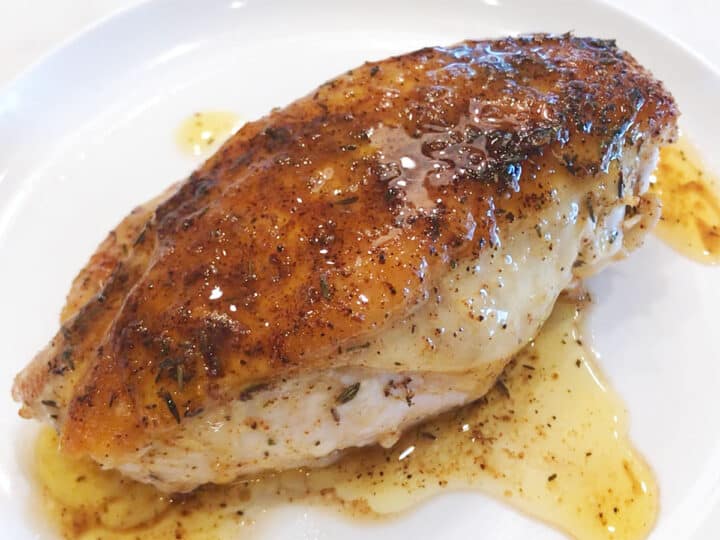 Pouring the pan juices over the chicken.