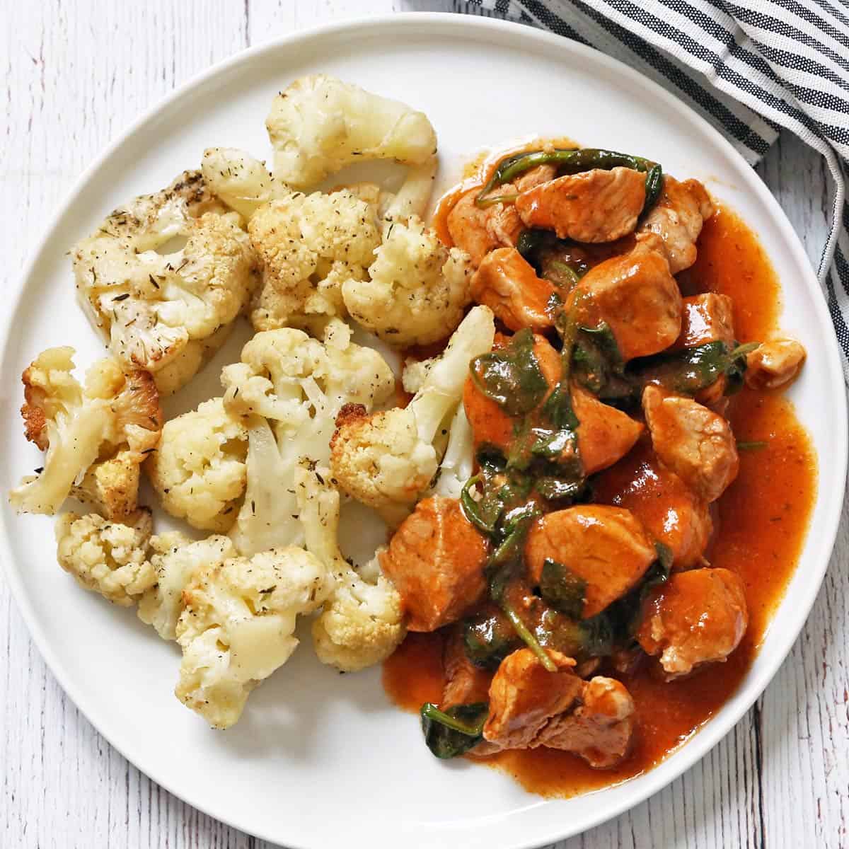 Pork stew is served with roasted cauliflower.
