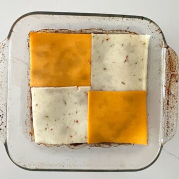 Topping the beef mixture with cheese slices.