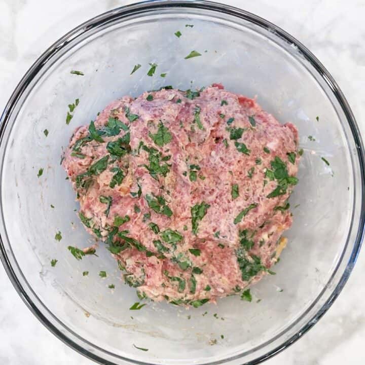 Lamb meatballs ingredients were mixed in a bowl.