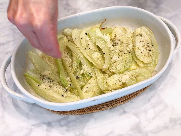 Sprinkling grated parmesan on top of the fennel.