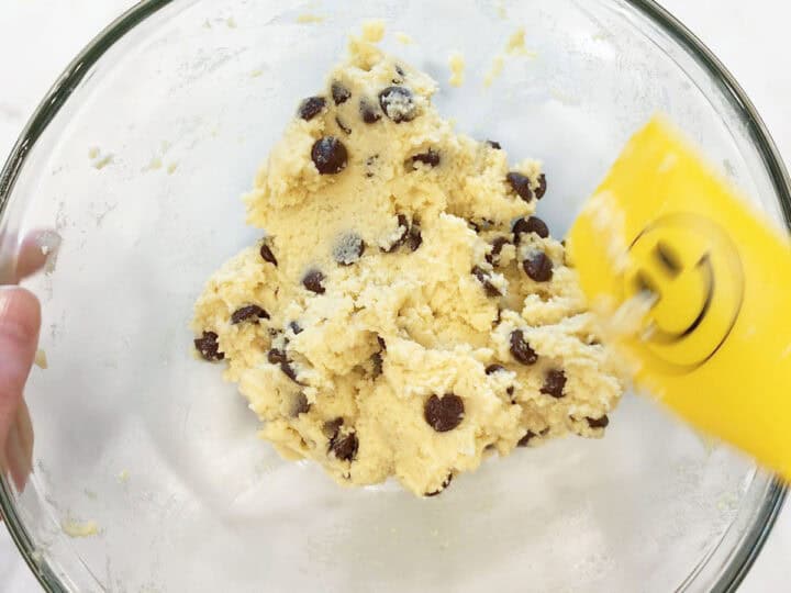 Adding chocolate chips to the batter.