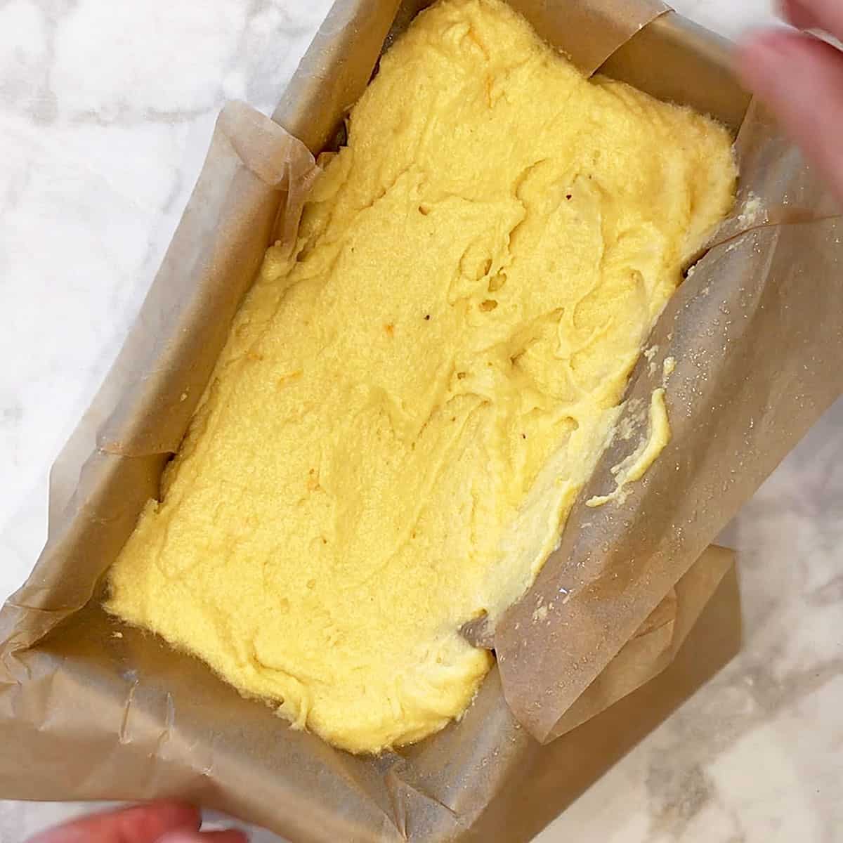 The batter in a parchment-lined loaf pan.