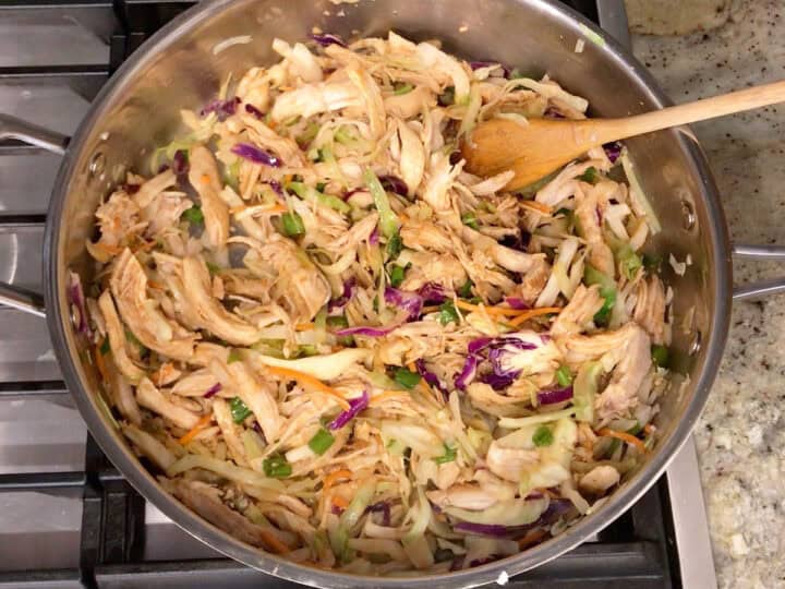 Coating the veggies and chicken in the sauce.