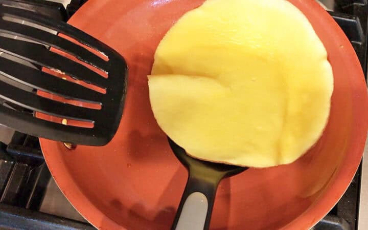 Flipping a pannekoek in the skillet.