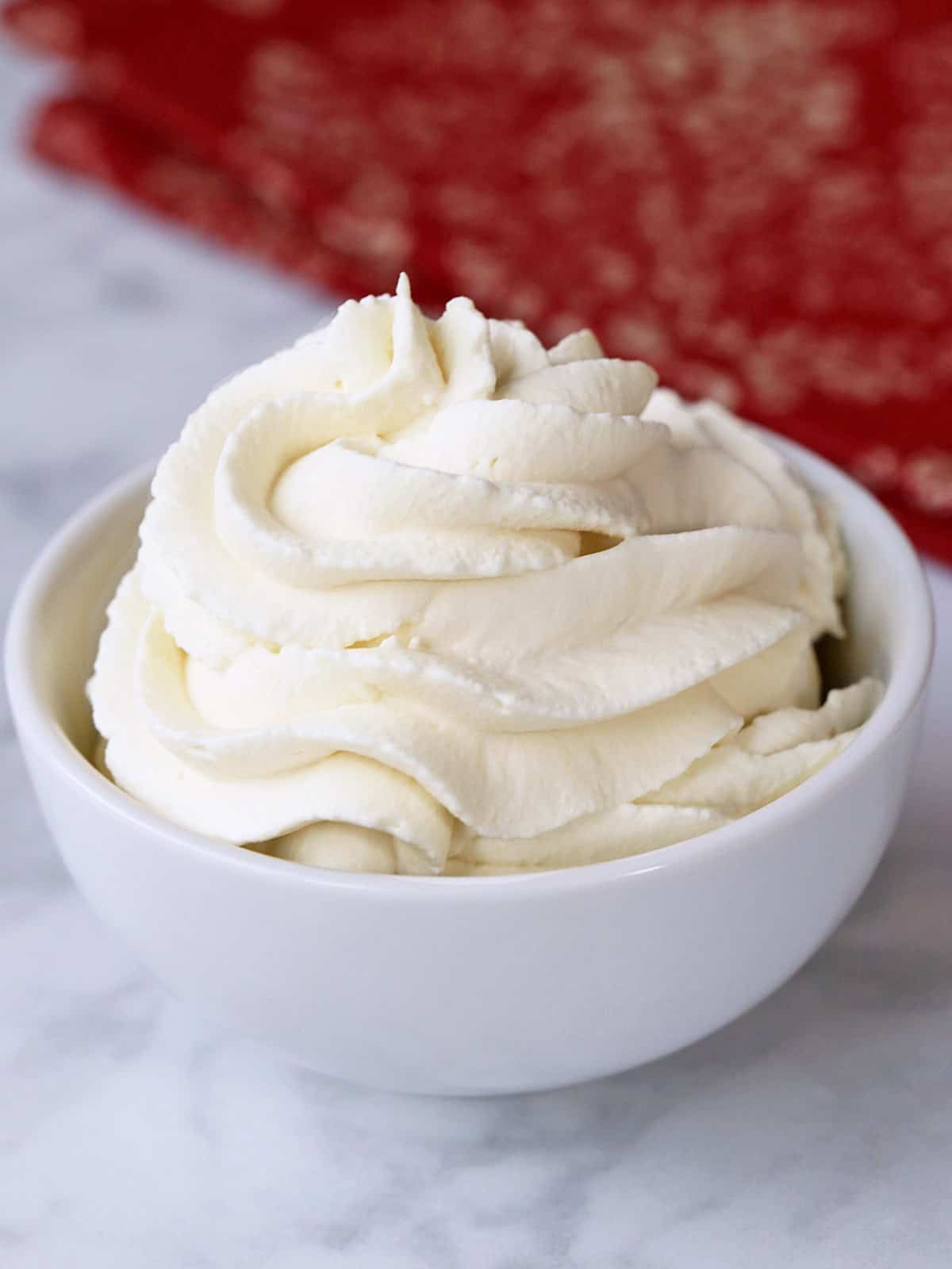 Sugar-free keto whipped cream is served in a bowl with a napkin.