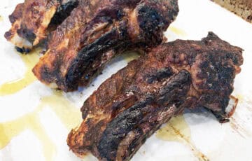 The ribs are ready in the pan, but can go for one more hour in the oven.