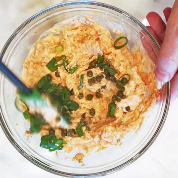 Adding capers and scallions.