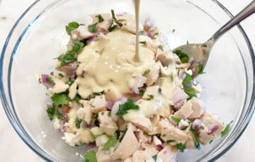 Adding the dressing to the salad.