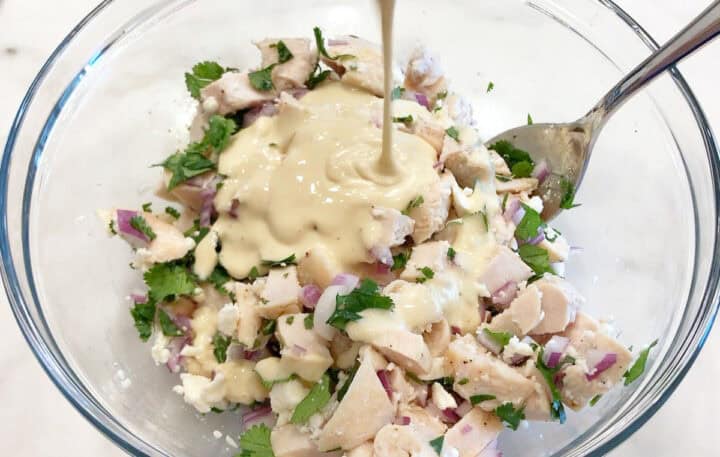 Adding the dressing to the salad.