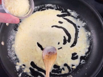 Adding parmesan to the sauce.