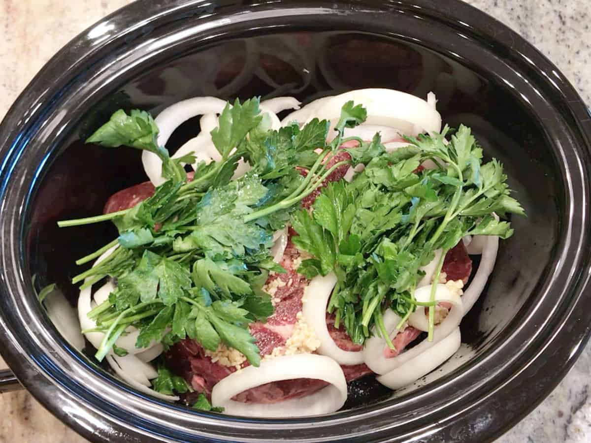 Veggies were added to the slow cooker pan.