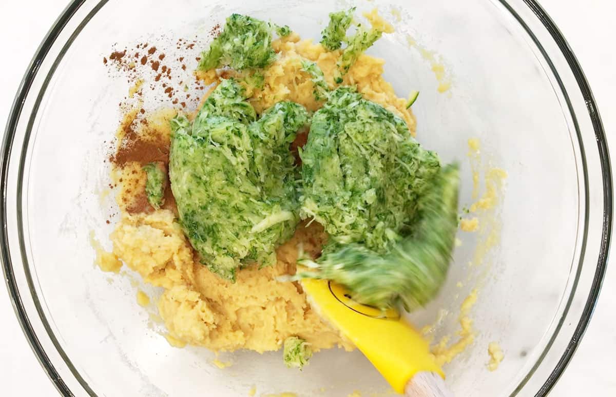 Adding almond flour and drained zucchini to the batter.