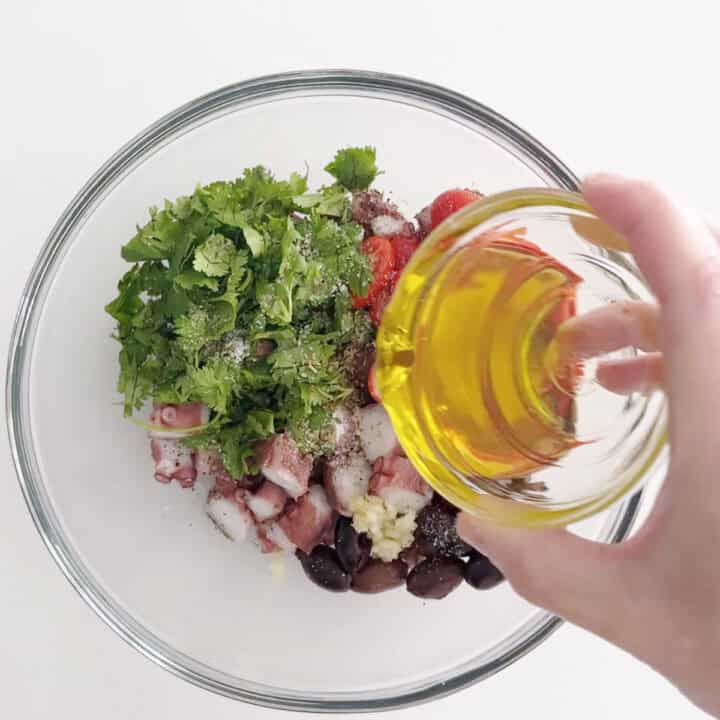 Adding olive oil to the salad.