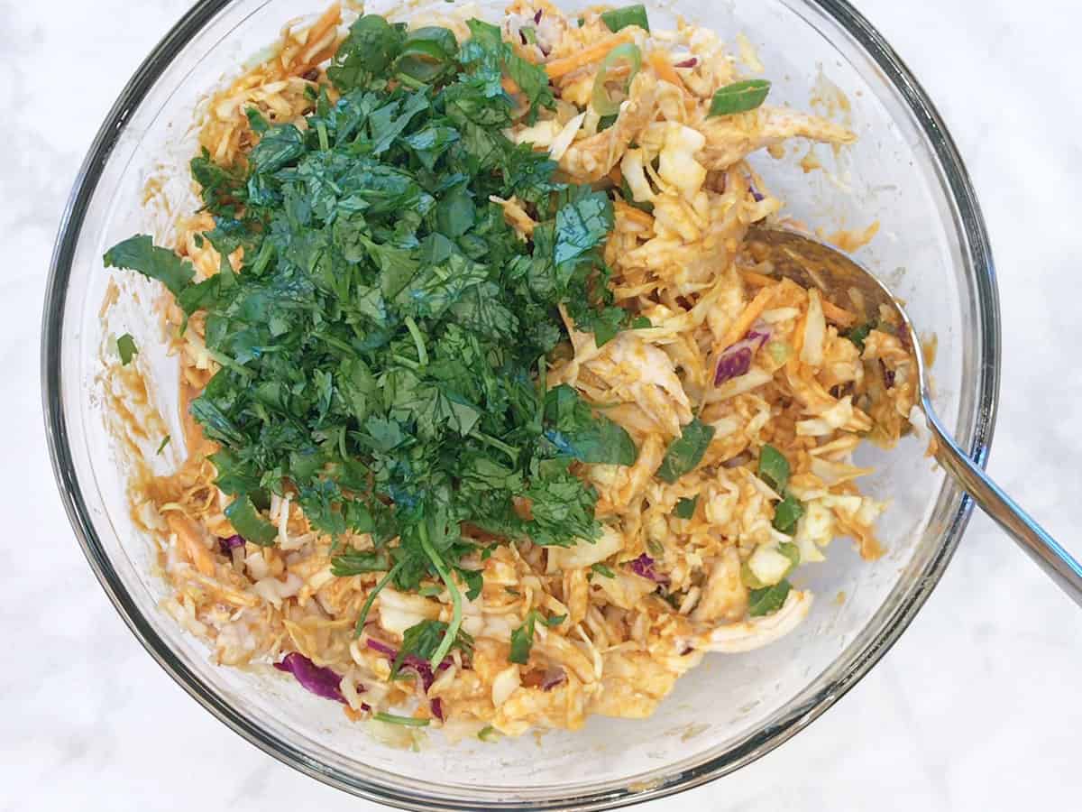 Adding the salad ingredients to the bowl.