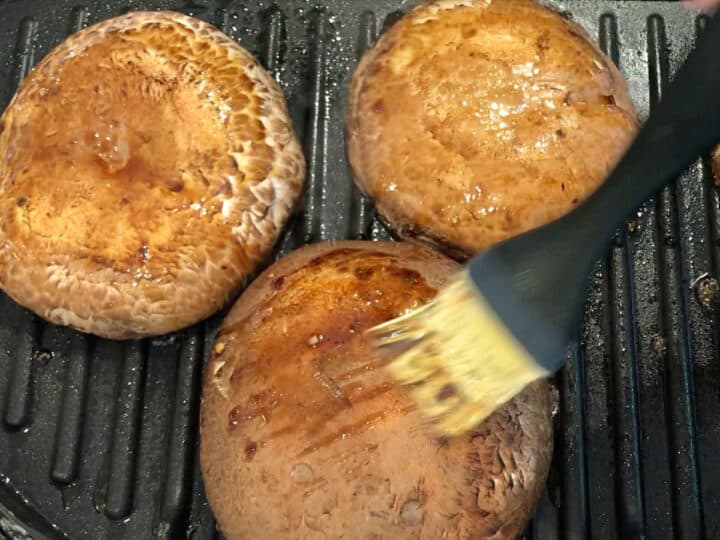 Brushing the tops with the marinade.
