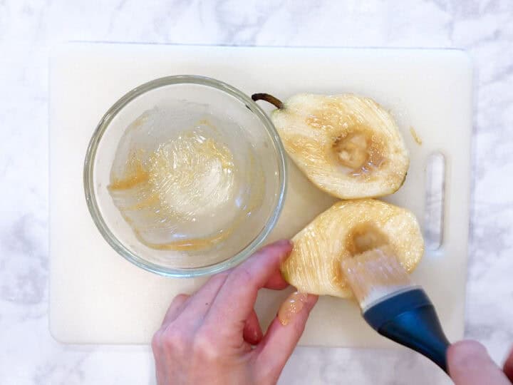 Coating the pears in melted butter.