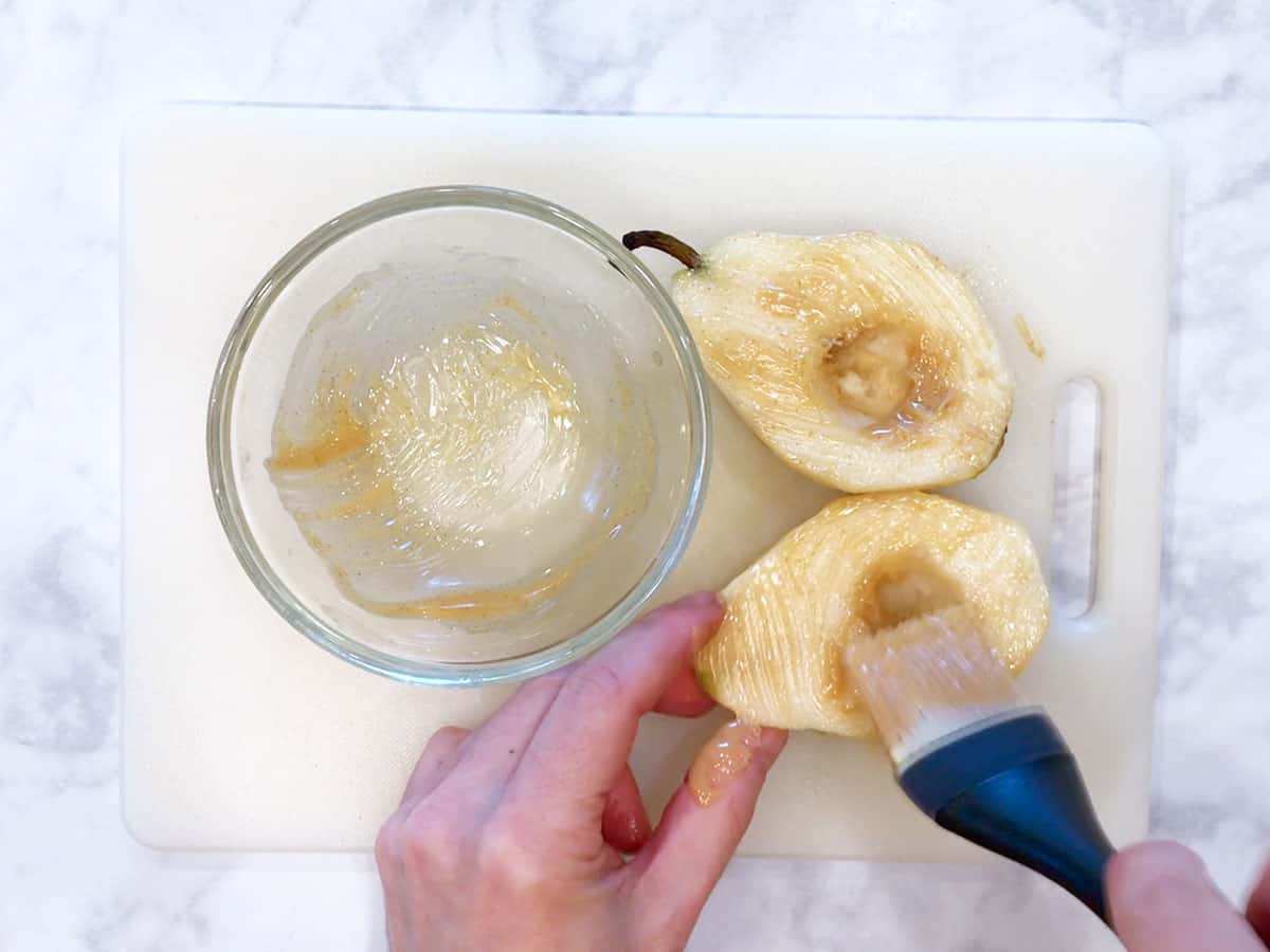 Coating the pears in melted butter.