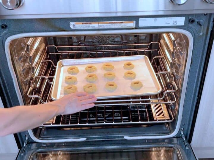 Placing the cookies in the oven.