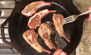 Cooking lamb chops in a cast-iron skillet.