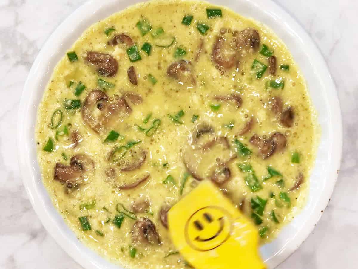 Adding the mixture to the pie plate.