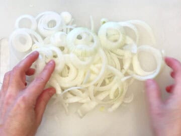 Sliced onions on a cutting board.
