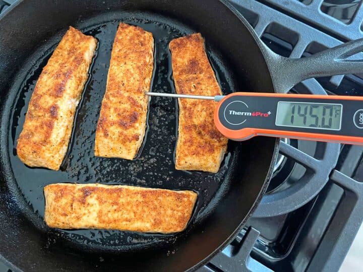 Broiled salmon in the pan has reached 145°F.