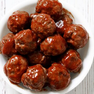 Cocktail meatballs are served in a white bowl.
