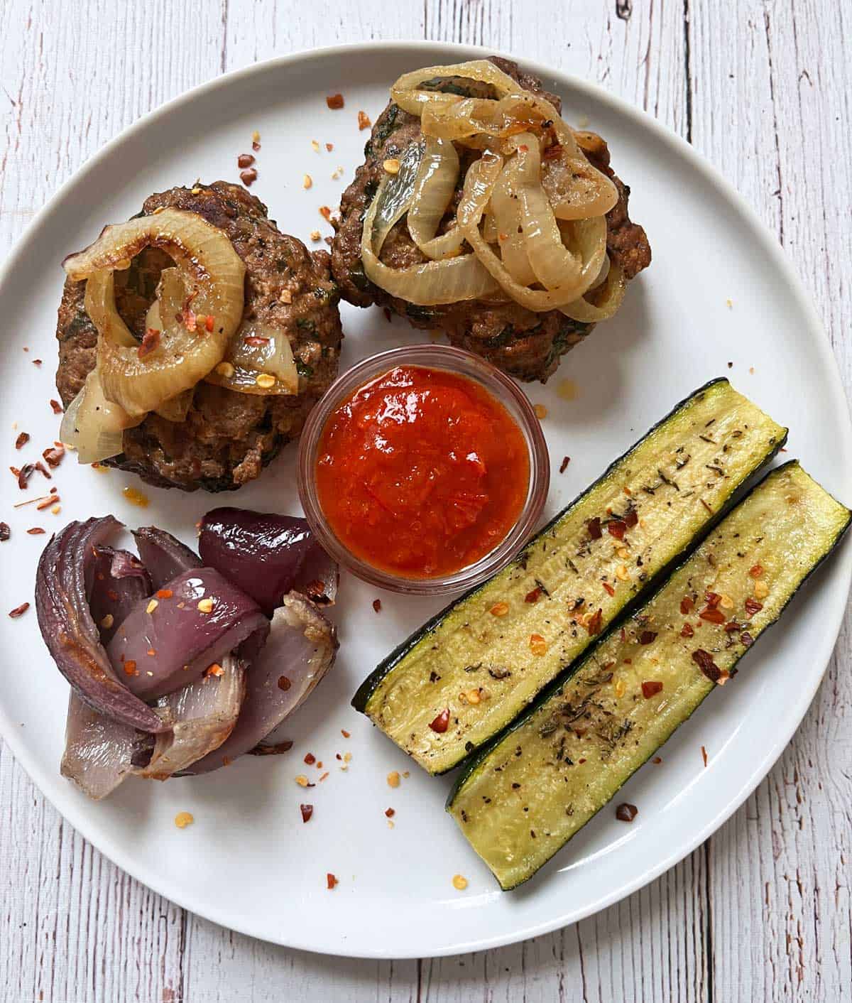 Lamb burgers are served with roasted veggies.