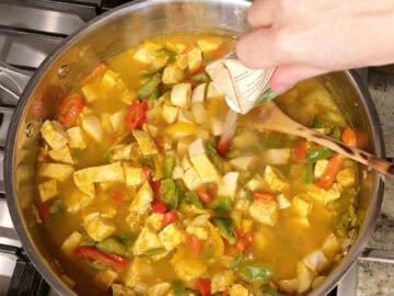 Adding broth to the curry.