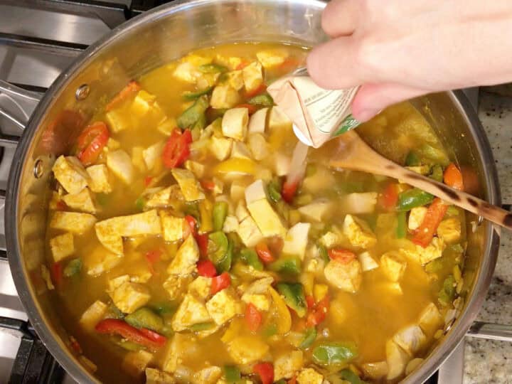 Adding broth to the curry.