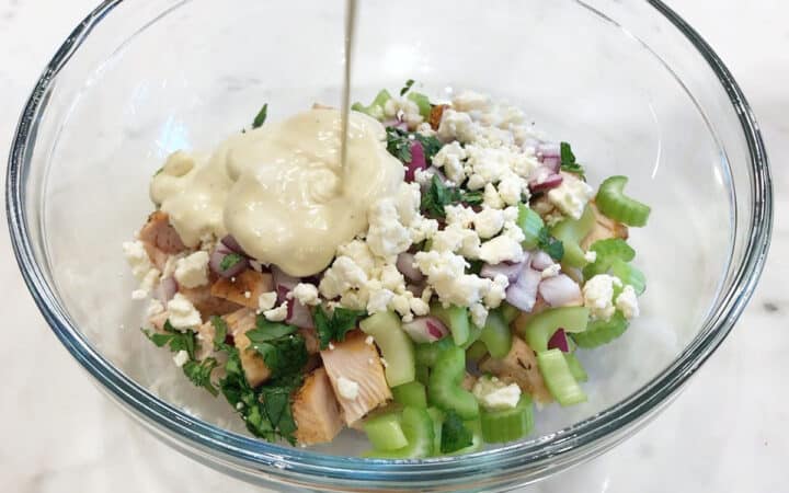 Adding the dressing to the salad.