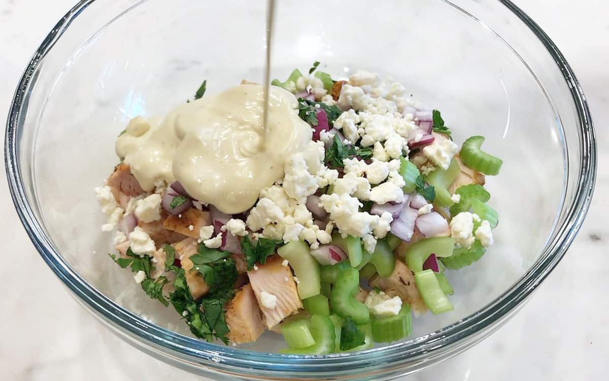 Adding the dressing to the salad.