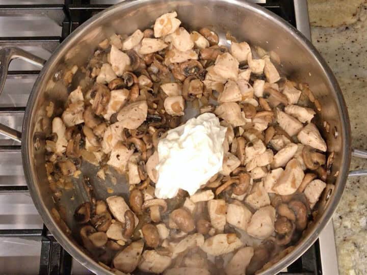 Adding the sour cream to the skillet.