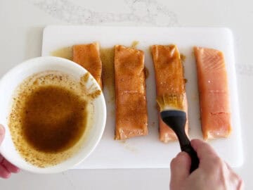 Coating the salmon pieces in sauce.