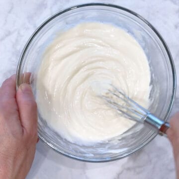 Mxing softened cream cheese with a sweetener and vanilla.