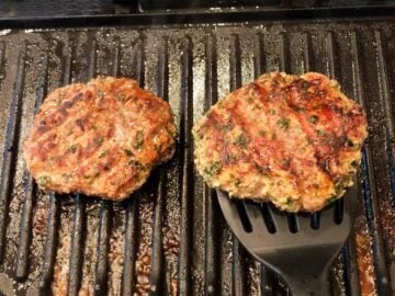 The burgers are grilled on the second side.