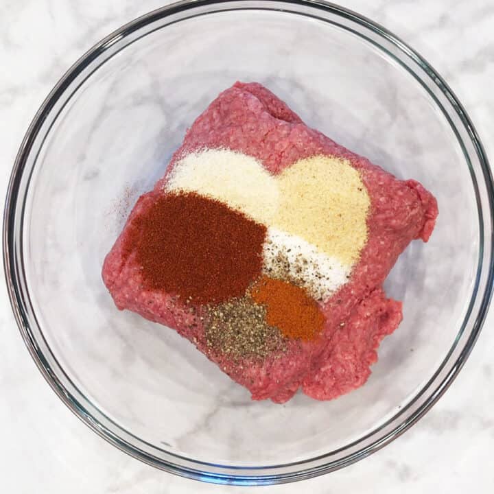 Ground beef and spices in a bowl.