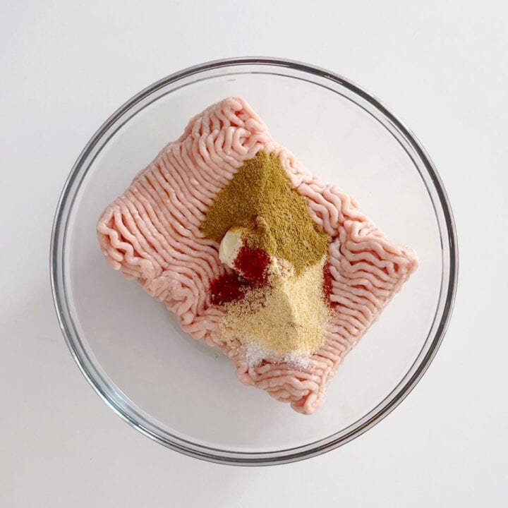 Ground chicken and spices in a bowl.